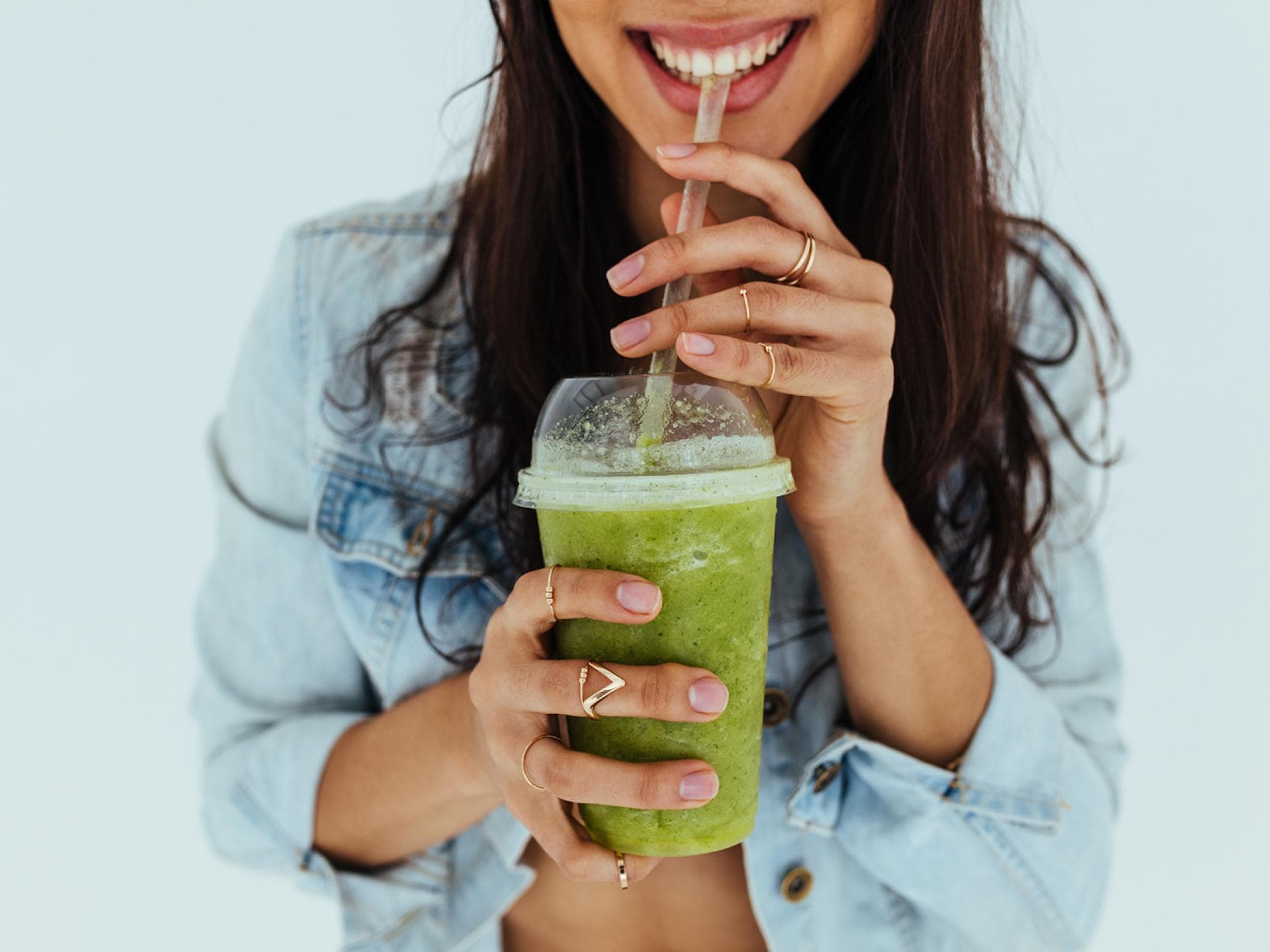 Eine Frau trinkt einen grünen Smoothie