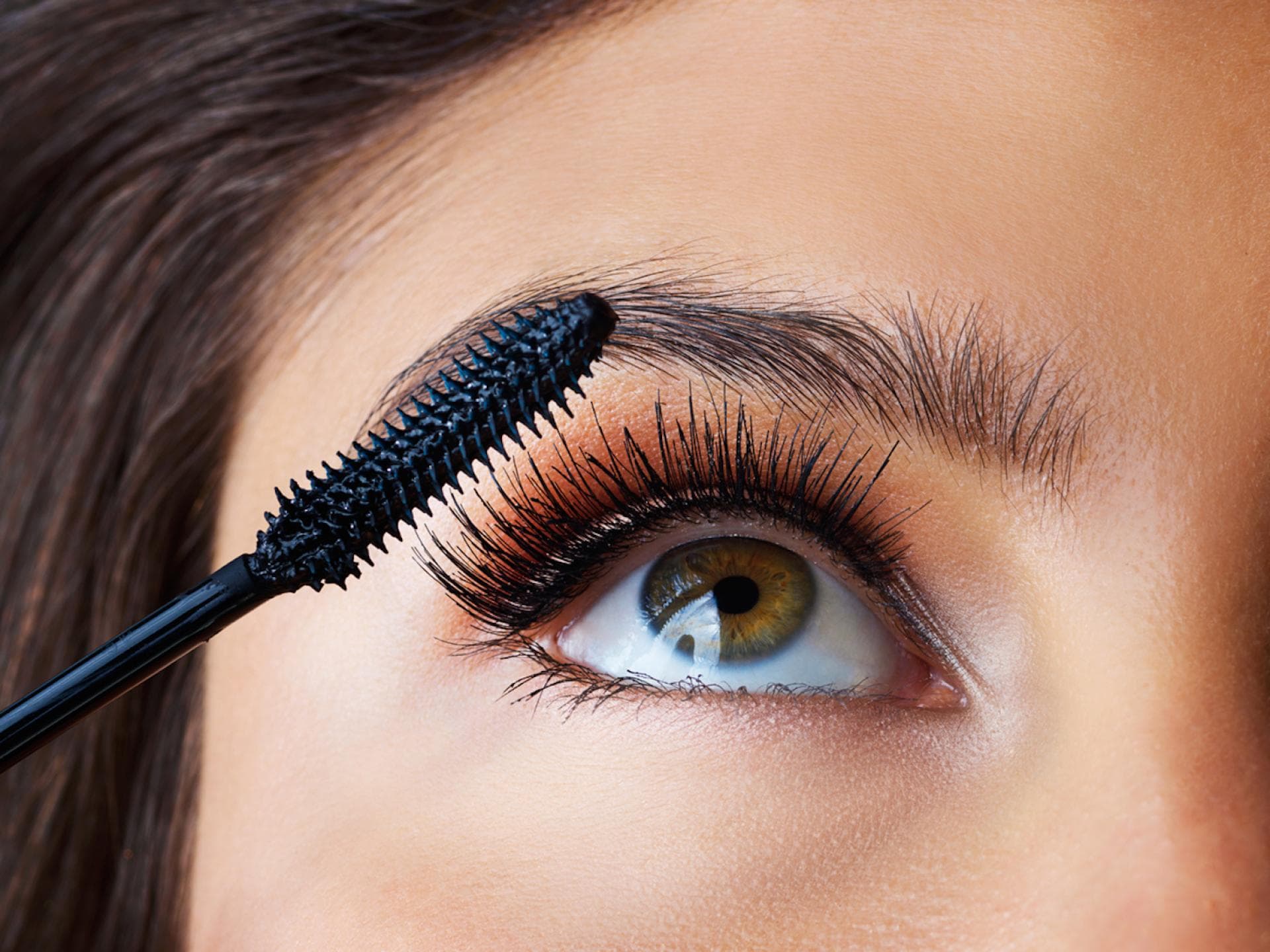 Frau tuscht ihre Wimpern