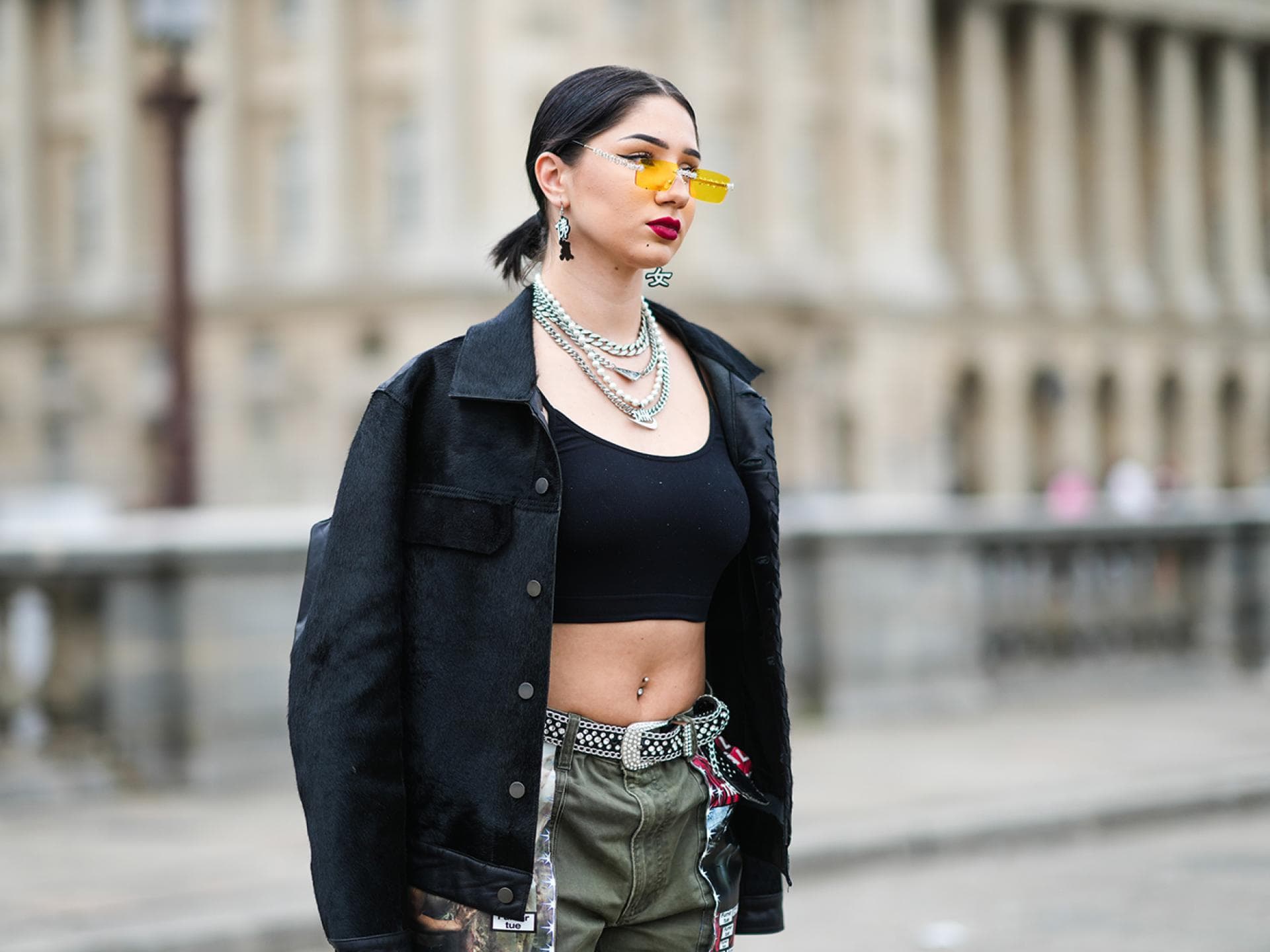 Lycia Lamini trägt ein bauchfreies Top und eine gelbe Sonnenbrille