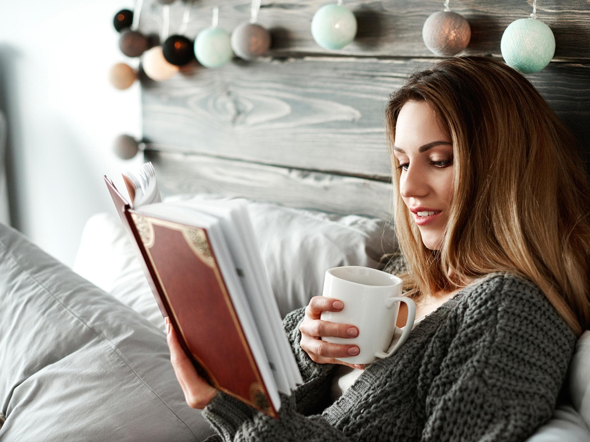 Frau liest Buch im Bett