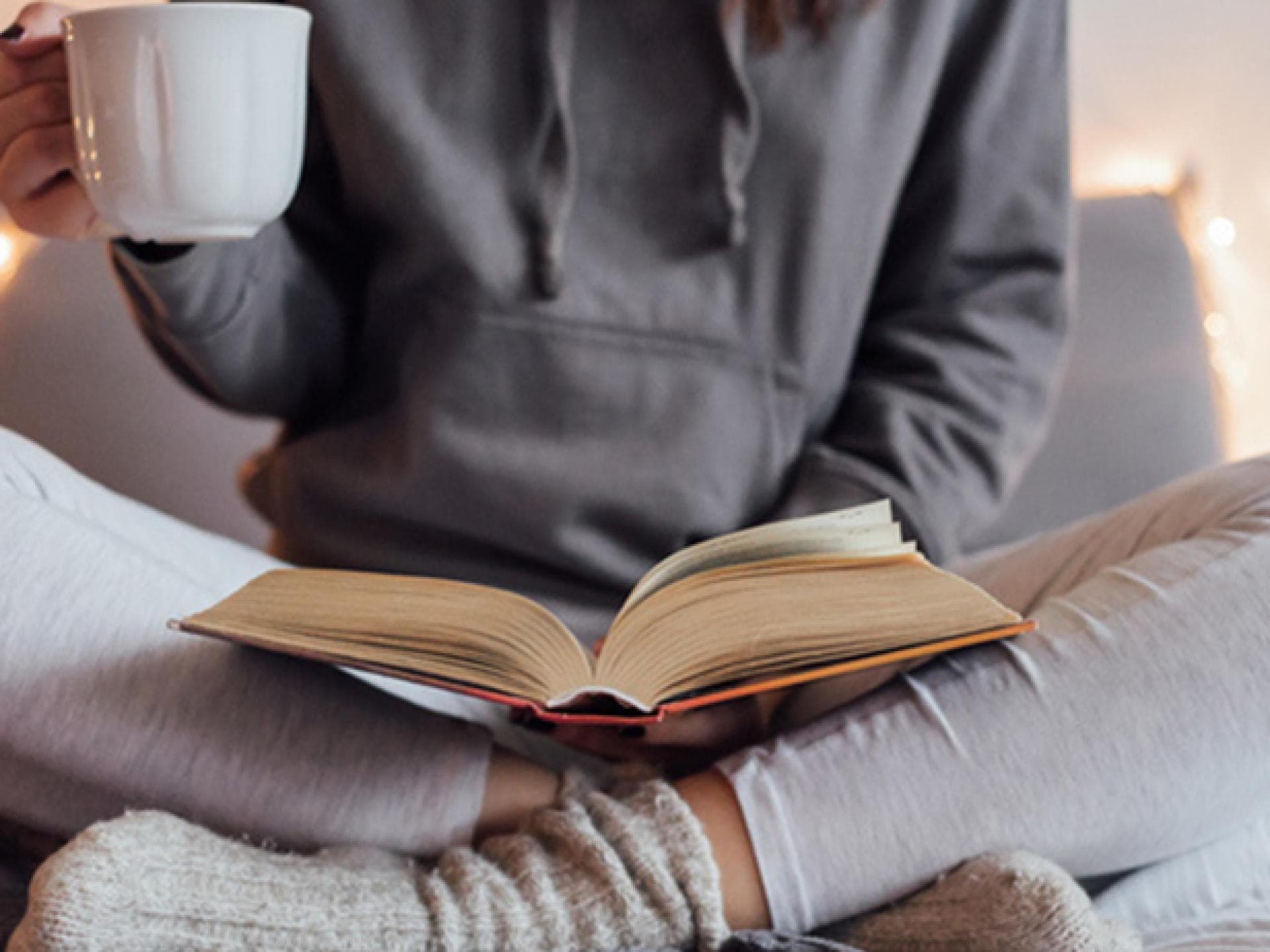 Frau im Schneidersitz liest Buch Frau im Schneidersitz liest Buch