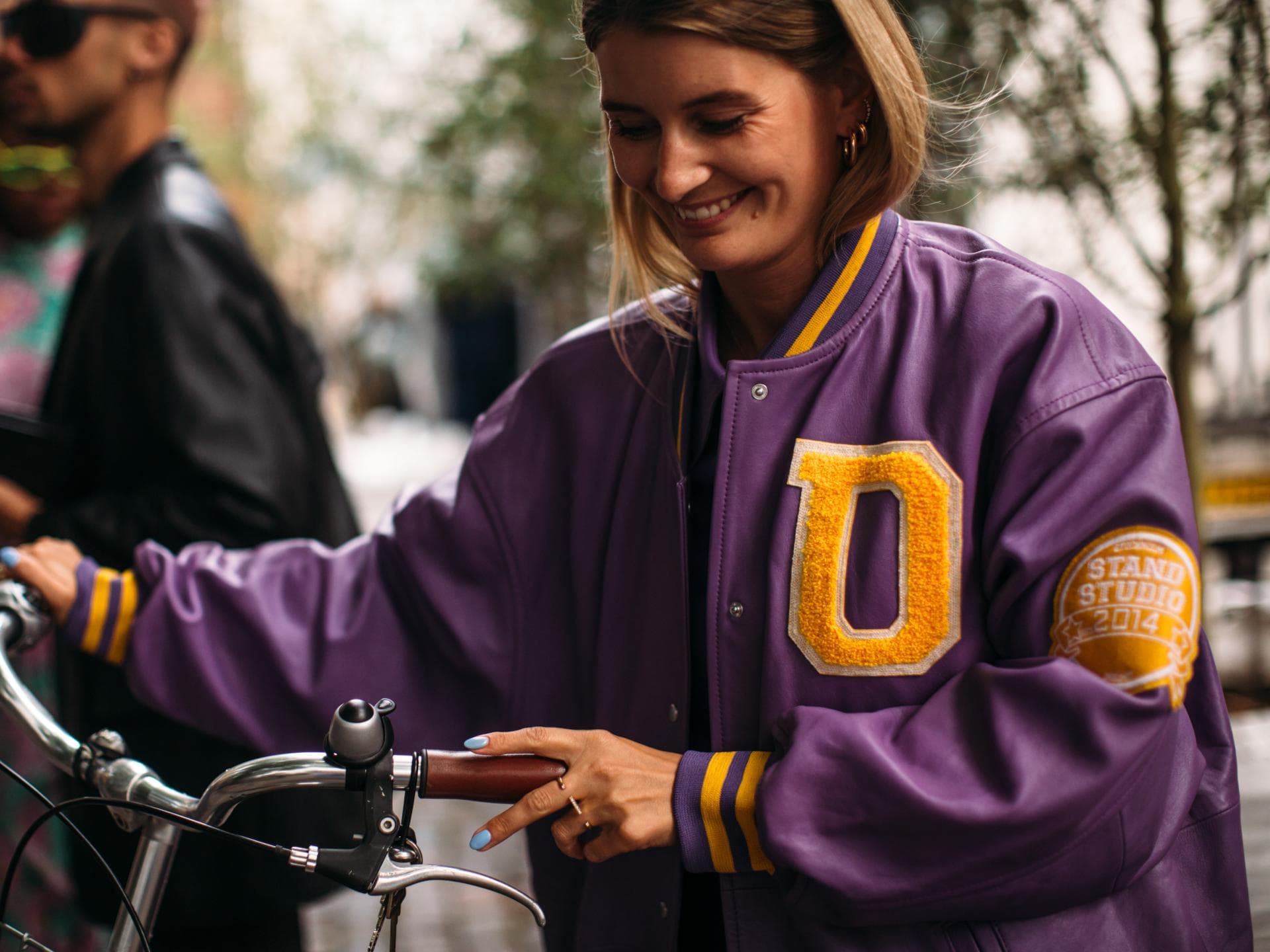 Frau mit einer lilafarbenen Collegejacke aus Leder