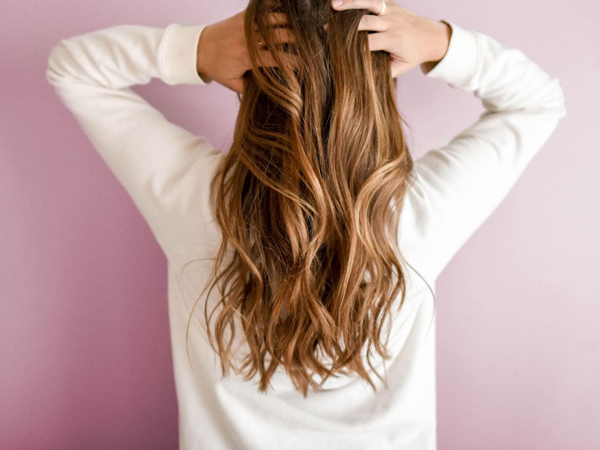 Frau greift sich in ihre langen Haare