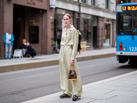Eine Frau trägt eine Sac Noé Tasche von Louis Vuitton
