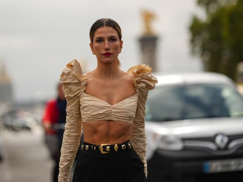 Frau trägt beiges Oberteil und goldenen Schmuck Streetstyle