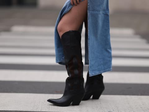 Cowboystiefel kombinieren: Eine Frau trägt Cowboystiefel zum Jeansrock