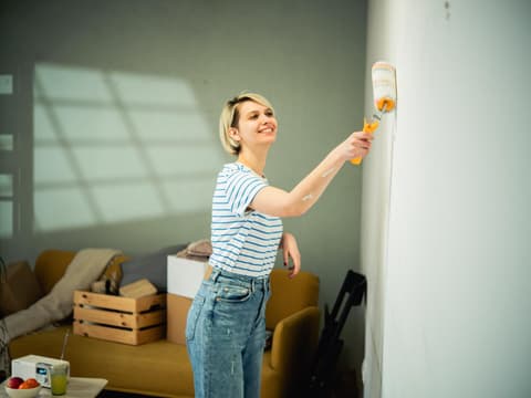 Frau streicht Wand