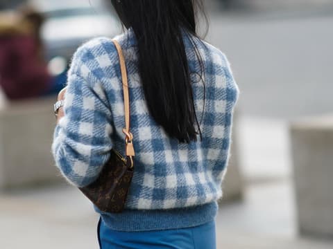 Eine Frau trägt eine Louis Vuitton Monogram Pochette Tasche