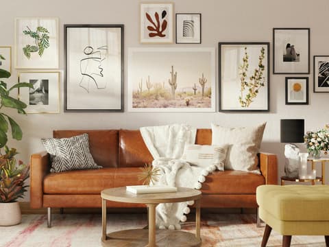 Stilvoll eingerichtetes Wohnzommer mit brauner Couch und Bildern an der Wand
