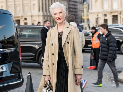 Maye Musk auf Dior Show 2023 mit beigem Trenchcoat und schwarzem Kleid Streetstyle lässige Kleidung für Frauen ab 60