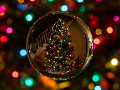 Bunte Lichterkette und Weihnachtsbaum in Kugel
