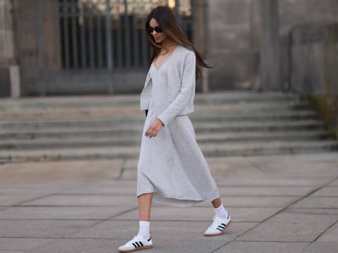 Frau trägt Kleid und weiße Sneaker