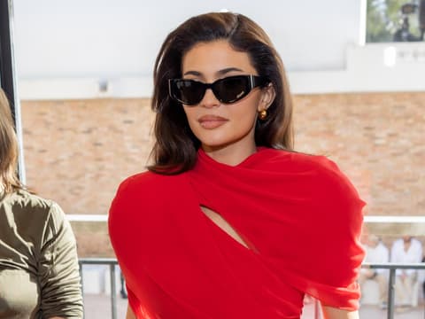 Kylie Jenner auf der Fashion Show von Jacquemus in einem roten Kleid und schwarzer Cat Eye Sonnenbrille