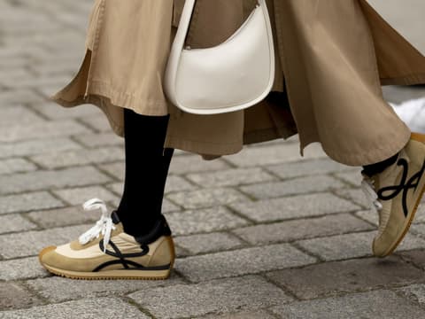 London Fashion Week Frau trägt beigefarbenen Sneaker und Rock