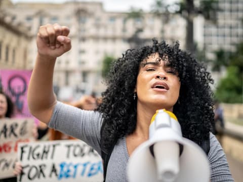 Frau hält Megafon bei Demonstration
