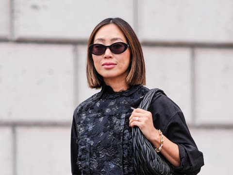 Influencerin Aimee Song mit einem Haarschnitt für dünnes Haar und Sonnenbrille im schwarzen Outfit