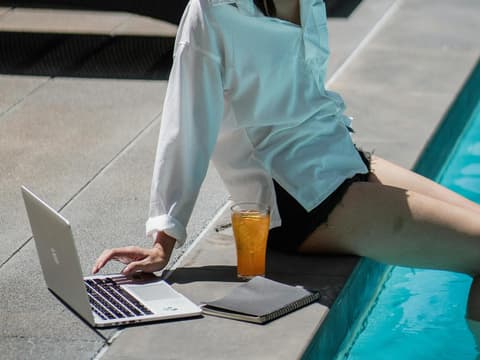 Frau macht "Quiet Vacation" mit Laptop am Pool