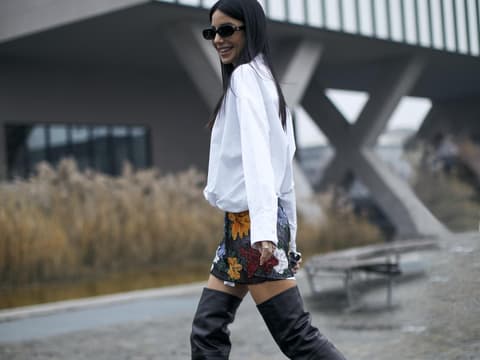 Frau stylt Overknee Stiefel mit Bluse